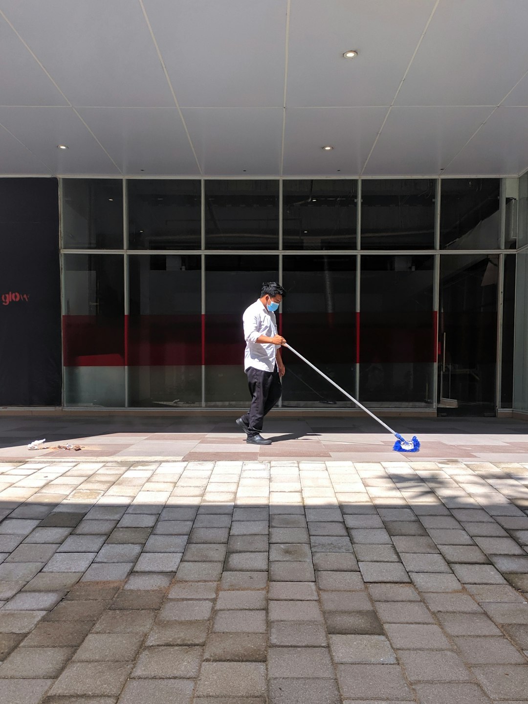 a-man-with-a-mop-on-a-sidewalk-vk5-eu8aagy
